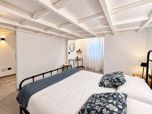 Camera moderna a Tolstoi 13.15 a Saronno con soffitto a cassettoni bianchi, letto in ferro nero e vista sulla città