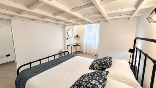 Camera moderna nell'appartamento Tolstoi 13 a Saronno con letto matrimoniale, struttura in metallo nero e vista città