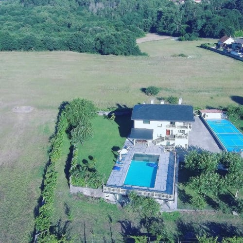 Aerial view of A Quinta de Lapido cottage with swimming pools and tennis court surrounded by green grounds in Spain