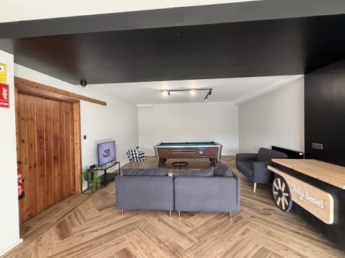 Recreation room at A Quinta de Lapido cottage with pool table, sofa seating, TV, and wooden bar counter