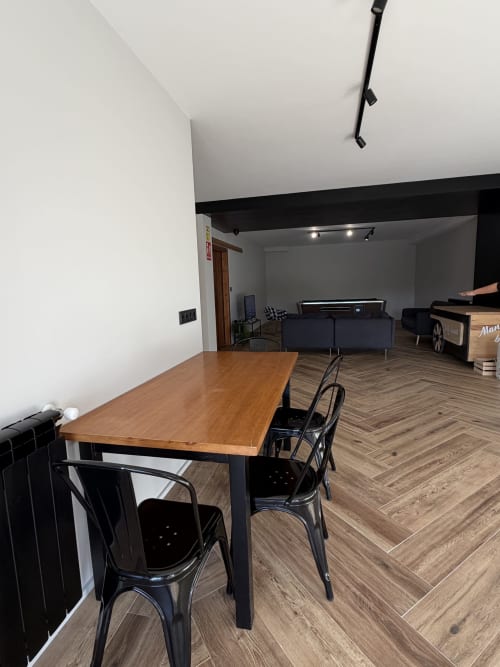 Modern private event space at A Quinta de Lapido with wooden table, black chairs, and lounge seating