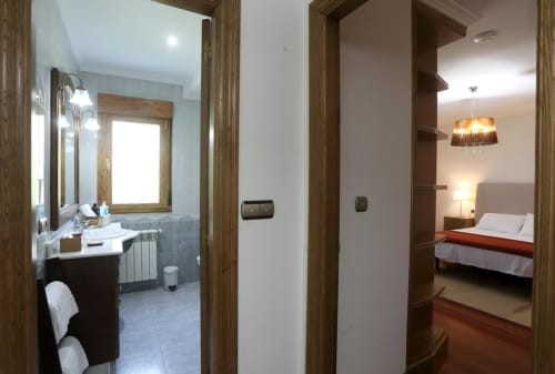 Habitación acogedora en A Quinta de Lapido mostrando entrada al baño, pasillo y dormitorio con cama en hotel español
