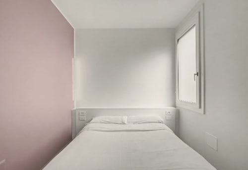 Minimalistische Hotelzimmer im Hotel Ca 'Tron in Dolo mit weißer Bettwäsche, rosa Akzentwand und Fensterblick