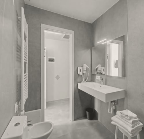 Modernes Badezimmer des Hotel Ca'Tron in Dolo mit weißem Waschbecken, Spiegel, Toilette und gläserner Duschkabine