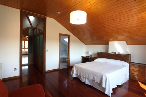 Amplio dormitorio doble con techo de madera y baño en suite en A Quinta de Lapido, casa rural española