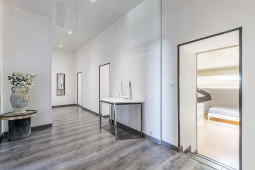 Modern hallway at Domaine De Pimpine cottage with wooden floors, white walls, and bedroom entrance