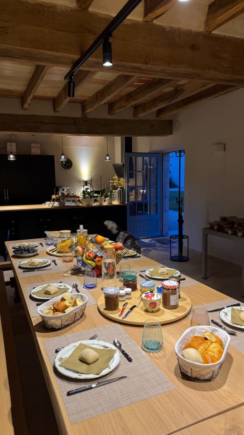 Elegant dining table set for dinner in Cloffy's reception hall with exposed beams and garden view doors in