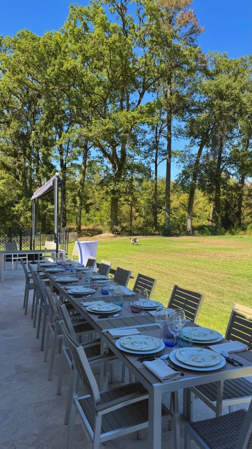 Outdoor dining setup at Cloffy reception hall with long table, elegant place settings, and forest views