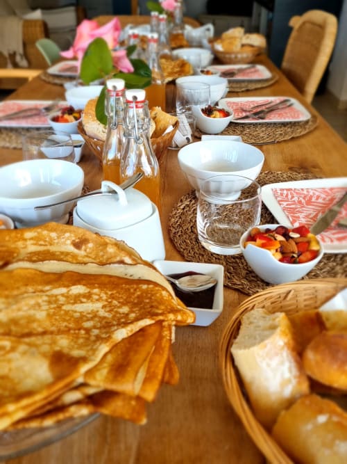 Petit-déjeuner maison à Ty Coz Breizh, chambres d’hôtes à Guidel en Bretagne Sud, avec crêpes bretonnes, pain frais, confitures maison et salade de fruits.