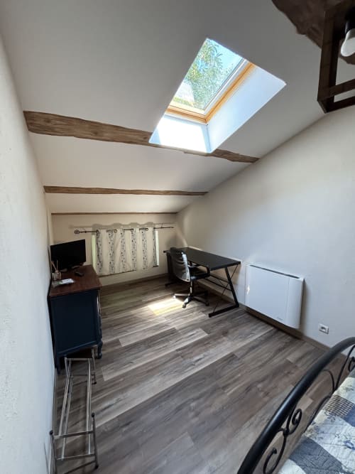 Chambre mansardée avec lucarne, poutres en bois, bureau et parquet au Mas Provençal, Bollène
