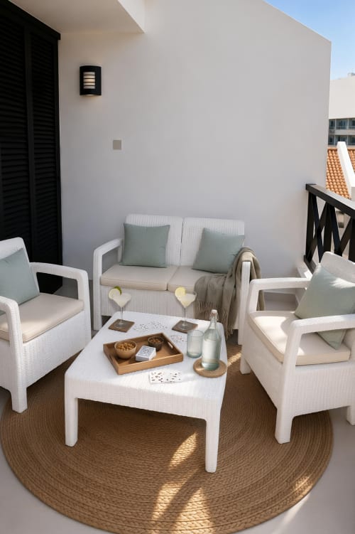 Luxury penthouse terrace at Manage Home Tenerife with white wicker seating, wooden table, sea view, and modern amenities in