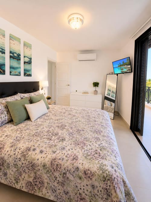 Luxury penthouse bedroom in Playa de las Américas with sea view, flat-screen TV, white furnishings, and modern amenities