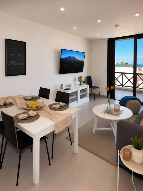 Luxury penthouse living room in Playa de las Américas with dining area, sea views, TV, and modern furnishings