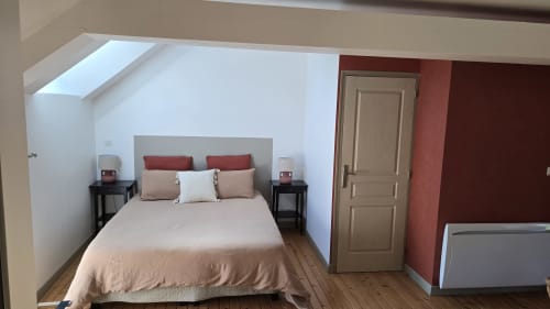 Chambre de Domaine de la Cour VAUTIER avec lit queen-size, touches rouges, puits de lumière et vue sur le jardin à Mandeville-en-Bessin