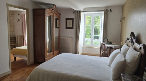 Chambre spacieuse avec literie blanche, mobilier en bois et vue sur le jardin à la maison d'hôtes Domaine de la Cour VAUTIER