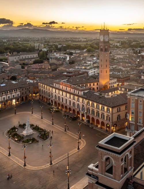 Vista aerea al tramonto della piazza storica di Forlì con torre dell'orologio e architettura rinascimentale