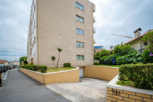 EcoHost apartment building exterior in Senhora da Hora, Porto with brick facade, landscaped entrance, and city views