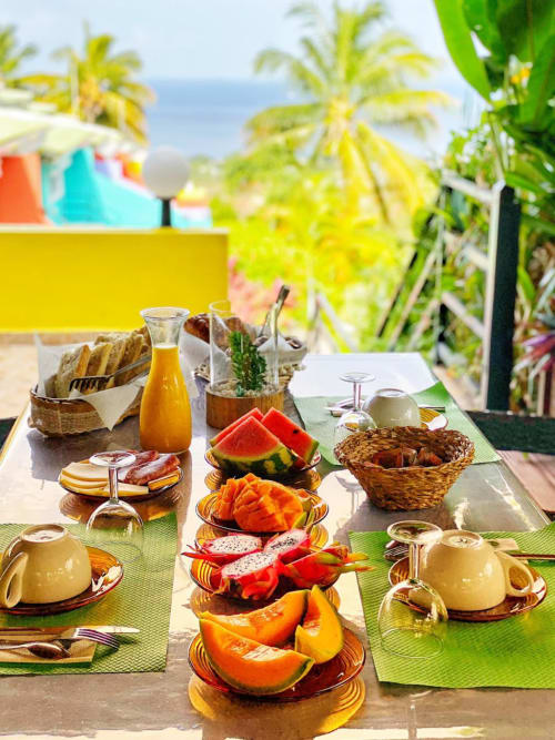 Petit-déjeuner tropical au Paradis Tropical avec fruits frais, pâtisseries et vue sur l'océan surplombant Baillif