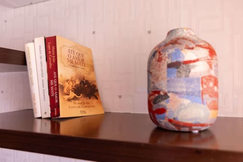 Books and decorative vase on wooden shelf in EcoHost apartment with sea view in Matosinhos
