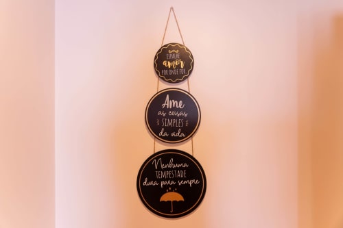 Decorative wooden wall hanging with Portuguese motivational phrases at EcoHost Matosinhos apartment