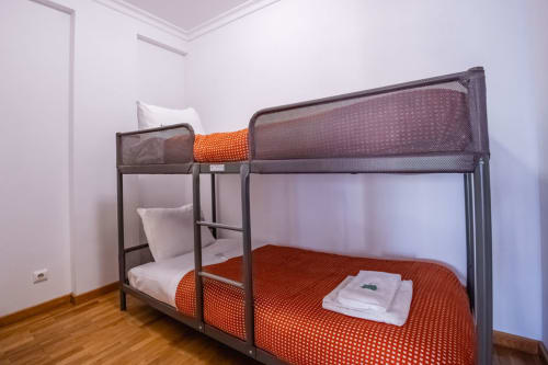 Family bunk bed with orange bedding in bright bedroom at EcoHost Matosinhos apartment