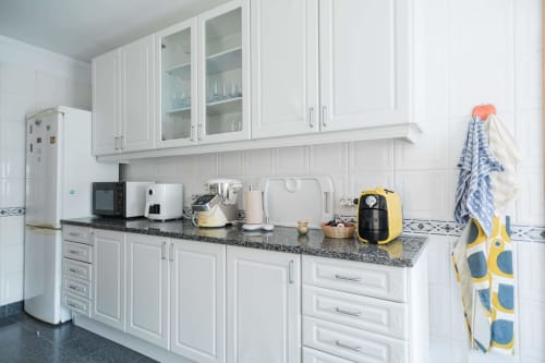 Modern white kitchen with granite countertop, stainless steel appliances, and full cooking amenities at EcoHost Gaia