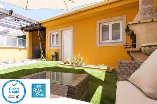 Bright yellow EcoHost apartment in Perafita with garden view, featuring outdoor seating, artificial grass, and patio area