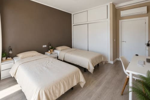 Premium shared room at Banama Coliving hostel in Corralejo with two beds, desk, and modern amenities