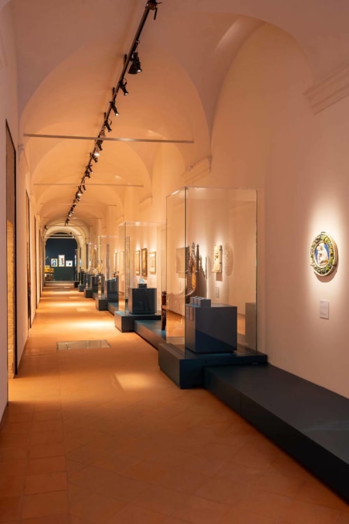 Elegante galleria museale della Corte Livia B&B a Forlì, con soffitto a volta, vetrine espositive e illuminazione calda