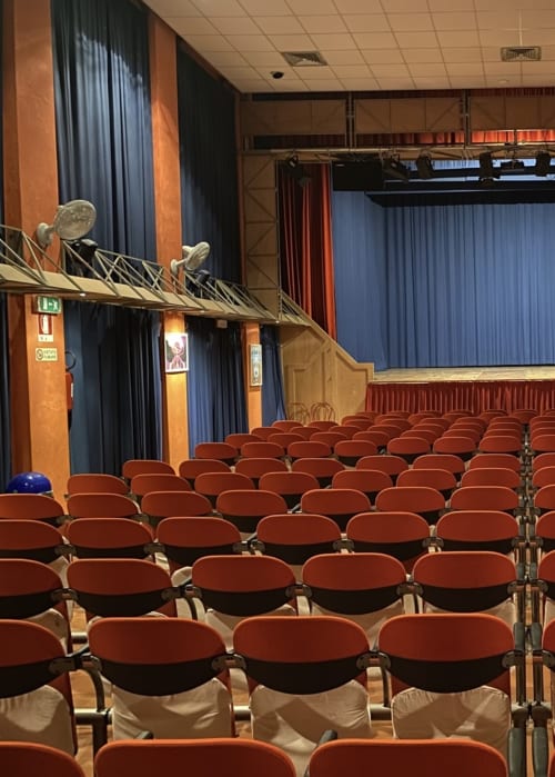 Sala teatro con sedili rossi e palco presso il Corte Livia B&B a Forlì, Italia