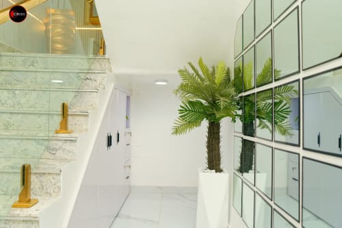 Modern bathroom at OD Cribs Abuja with marble walls, palm plant, mirrored cabinets, and contemporary fixtures