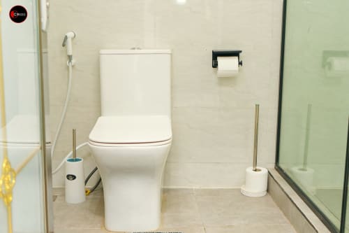 Clean modern bathroom at OD Cribs CASA apartment in Abuja with white toilet, shower area, and accessible fixtures