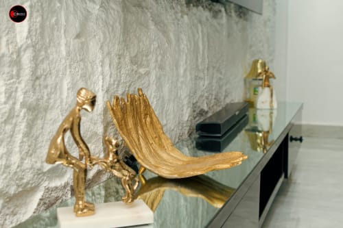 Gold sculptural art pieces displayed on shelf in CASA OD apartment at OD Cribs Abuja hotel room