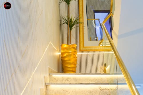 Modern staircase with gold accents and potted plant at OD Cribs hotel, Abuja