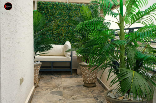 OD Cribs CASA apartment patio in Abuja with lush green plants, comfortable seating, and tropical ambiance