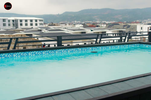 Rooftop pool at OD Cribs Abuja with city views, blue tiled swimming area overlooking modern apartments