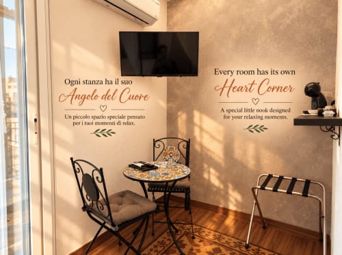 Accogliente angolo cuore nella camera Gli Amanti del B&B I Mori Catania con zona soggiorno, citazioni decorative e area relax