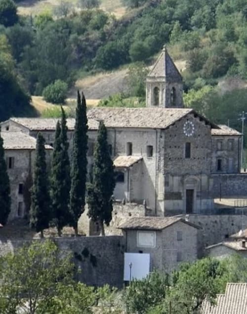 Antico monastero in pietra con campanile immerso nelle colline della campagna italiana vicino a Forlì