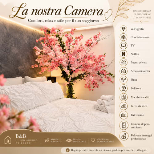 Elegante camera da letto in B&B a Catania con albero dai fiori rosa, biancheria bianca e moderni servizi tra cui WiFi, aria condizionata e smart TV