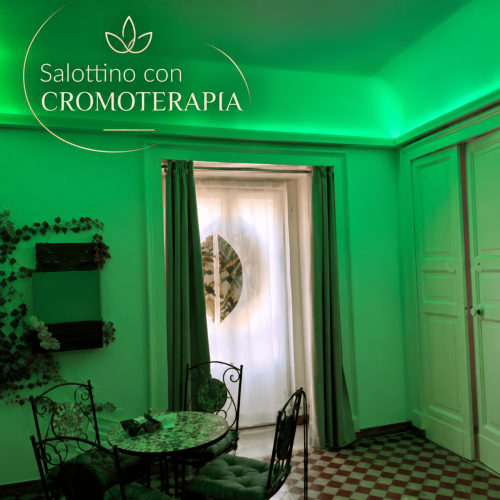 Jasny zielony pokój chromoterapii w B&B I Mori Catania z roślinami, czarnymi meblami i widokiem na miasto