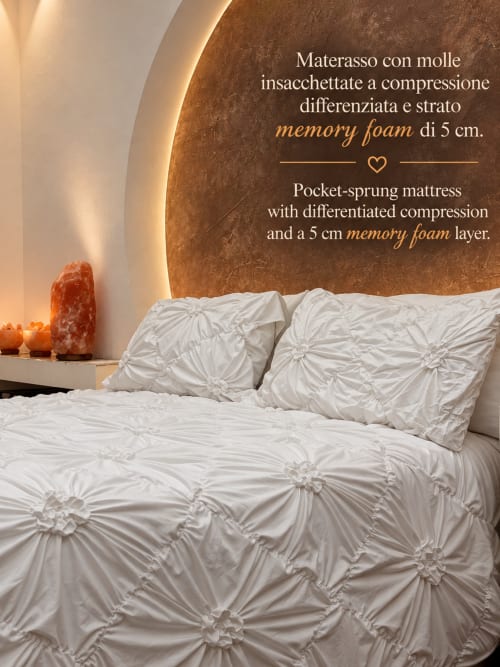 Cama lujosa con ropa de cama blanca texturizada y almohadas decorativas en B&B I Mori en Catania, con colchón de espuma viscoelástica