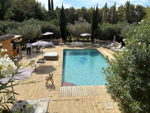 Sparkling pool surrounded by olive trees and sun loungers at Les Jardins Du Soleil, Avignon