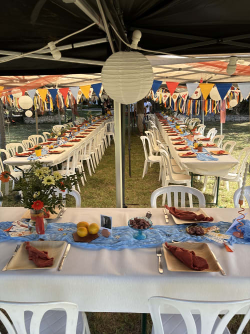 Colorful outdoor garden party setup at Les Jardins Du Soleil in Avignon with festive bunting and decorated tables