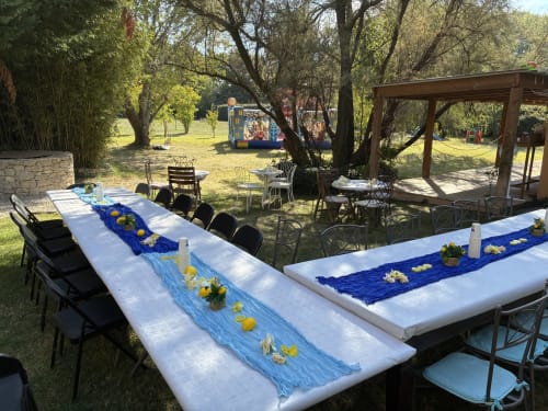 Outdoor garden banquet setup at Les Jardins Du Soleil with decorated tables and blue runners in Avignon