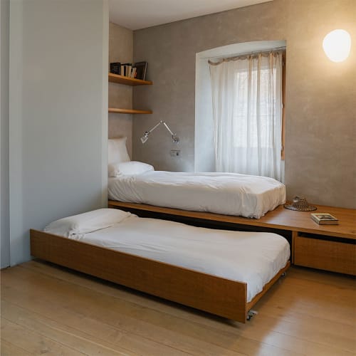 Modern bedroom at Alemanys 5 B&B in Girona with twin beds, wooden furniture, and contemporary lighting