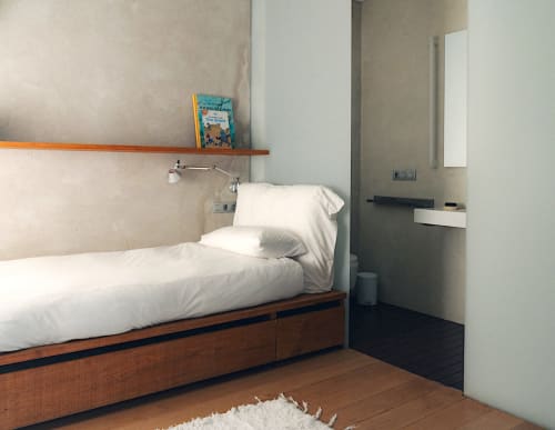 Minimalist bedroom at Alemanys 5 B&B in Girona with white bedding, wooden bed frame, and wall-mounted shelf