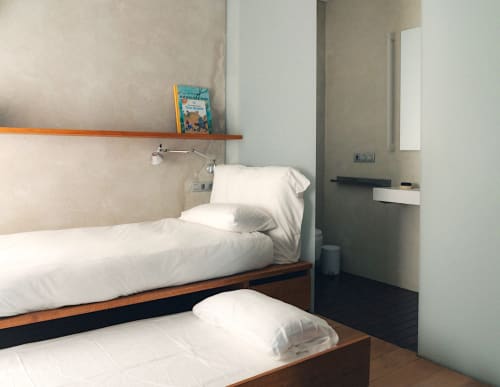 Compact twin bedroom at Alemanys 5 B&B in Girona with white bedding, wooden shelf, and minimalist design