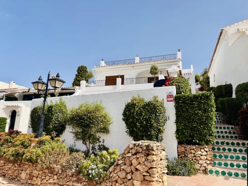 Villa de lujo blanca con vistas al mar en Nerja, arquitectura mediterránea, jardines en terrazas y muros cubiertos de hiedra