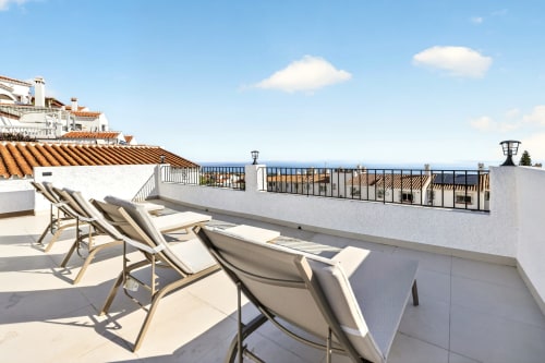 Lujosa terraza con vistas al mar en Villa Mandarinos, Nerja, con tumbonas y costa mediterránea