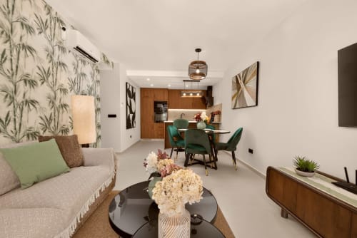 Elegante sala de estar de villa de lujo en Nerja con comedor, cocina, sofá y acceso a vista al mar